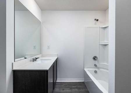 Sizable guest bathroom with plenty of countertop space and a bathtub. 