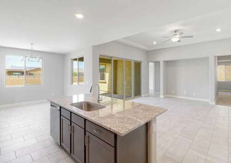 Bartlett kitchen and family room with built-in entertainment center, ceramic floors, and granite island with sink