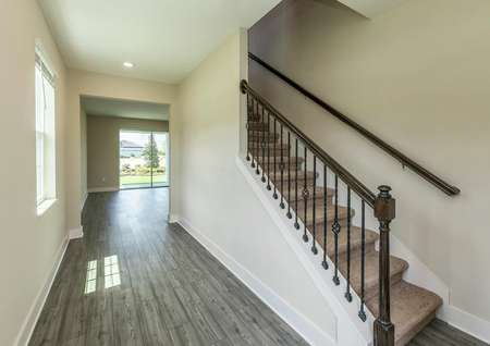 A beautiful staircase and luxury vinyl plank flooring at the home's entrance.