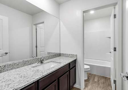 Secondary bathroom with a double-sink vanity and a private restroom.