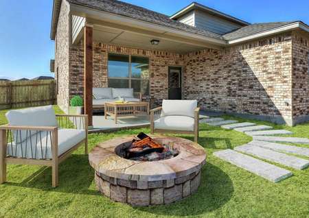Staged back yard with a fire pit and sitting area.