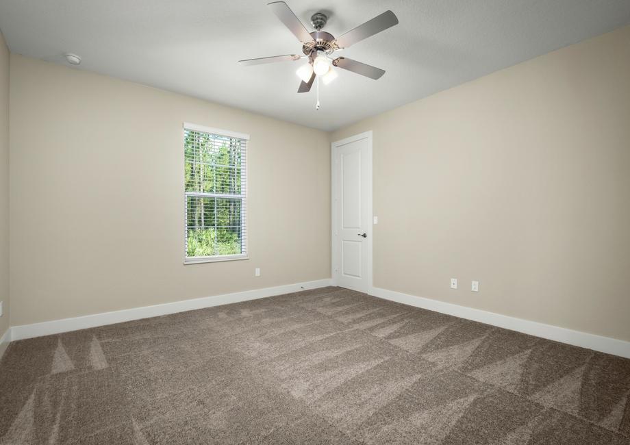 Secondary bedroom with a window and carpet.
