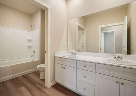 Secondary bathroom with white dual-sink vanity.