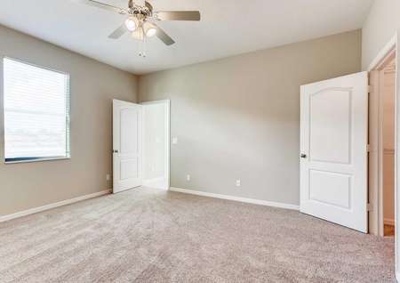 The Santa Maria model home's master bedroom. Spacious room with carpet, white baseboards and tan walls