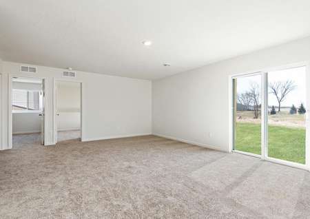 Game room with carpet and sliding glass doors to backyard, access to adjacent bedrooms and bathroom.