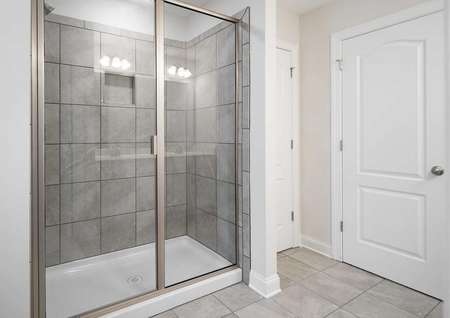Fripp master bathroom with custom tile shower, tiled floors, and white doors and trims