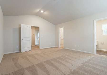 Master bedroom with tan carpet and tan walls.