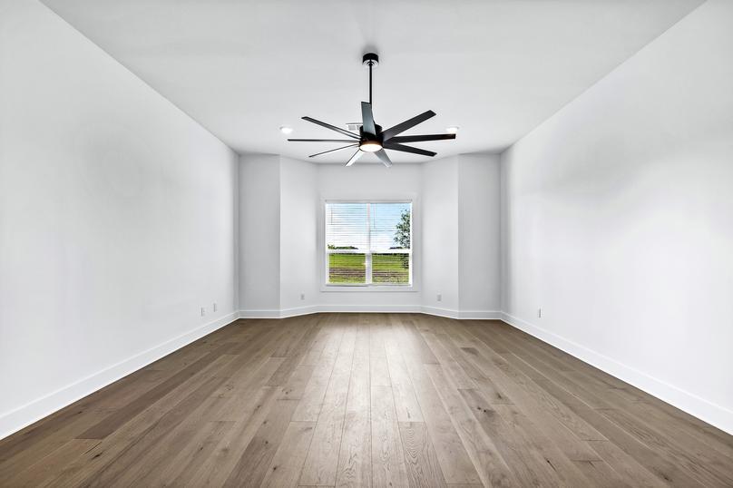 Fall in love with the incredible master bedroom with wood flooring and a ceiling fan.