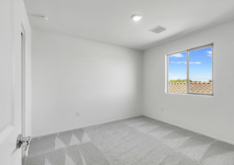 Guest bedroom with large windows, creating a bright space.