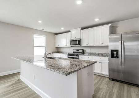 Kitchen with white cabinets, granite countertops and stainless steel appliances.