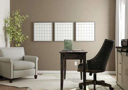 Rendering of a secondary bedroom with
  window and brown accent wall decorated as an office with desk, file cabinet
  and gray armchair. 