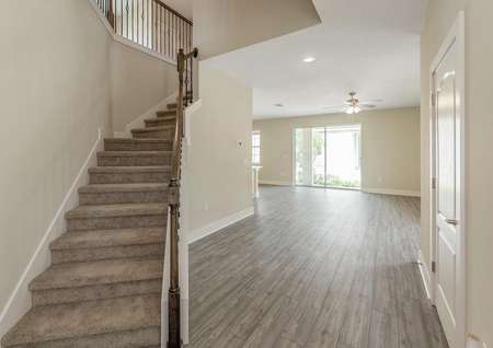Entrance of two-story Verona floor plan with a beautiful staircase, luxury vinyl plank flooring and plenty of natural light entering the home.