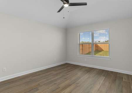 Master bedroom with plank flooring and a ceiling fan