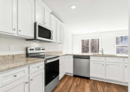 Kitchen with granite countertops, white cabinets and vinyl flooring.