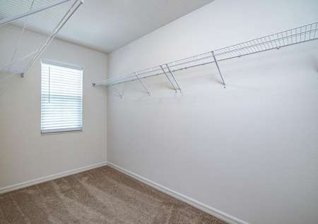 A large walk-in closet with a window is connected to the master bedroom. 