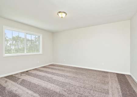 Photo of a bedroom with carpet and a large window.