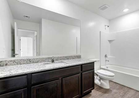 Secondary bathroom with a dual shower and bath tub and a single-sink vanity.