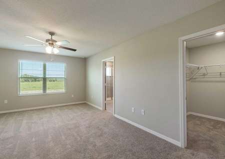 The master bedroom in the Tuscany floor plan that has a view of the walk-in closet and the master bathroom.