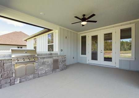 Covered outdoor kitchen with fan and built-in grill.