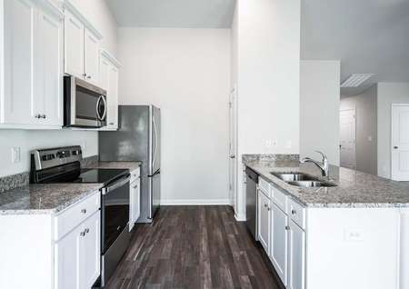 Chef-ready kitchen with granite countertops, white cabinetry and stainless steel appliances. 
