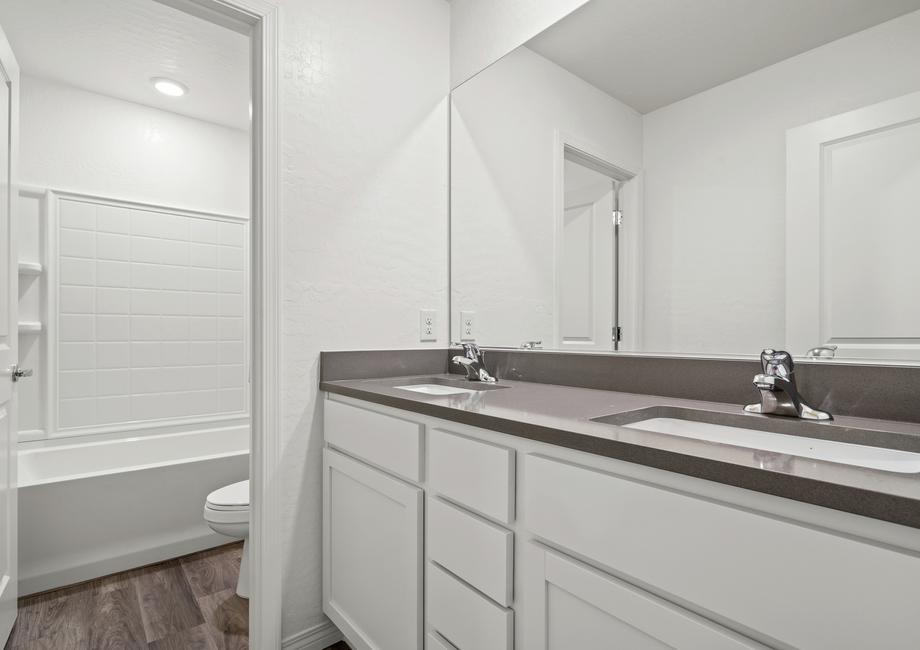 Secondary bathroom with a dual sink vanity and a tub/shower combo