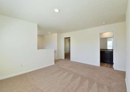 Spacious upstairs game room with carpet and door to bathroom and bedroom.