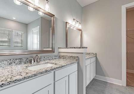 Master bathroom with two large vanities, granite countertops and large mirrors.