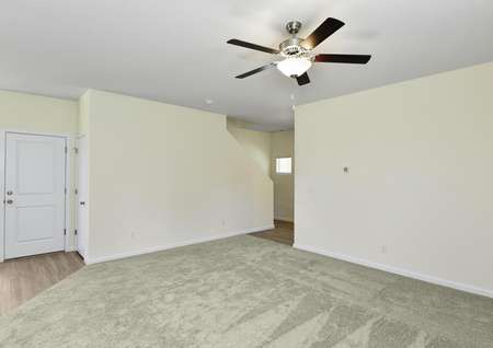 Spacious family room with carpet and a ceiling fan