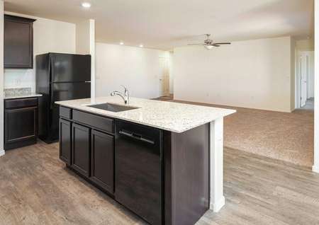 The Roosevelt floor plan kitchen shown with a granite island and vinyl wood flooring.