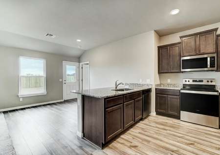 A chef-ready kitchen with stainless steel appliances and granite countertops overlooking a spacious dining area.
