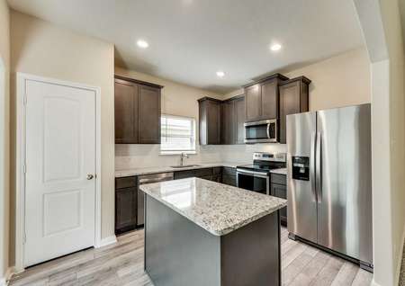 Erie kitchen with granite counters, food prep island, and stainless steel appliances
