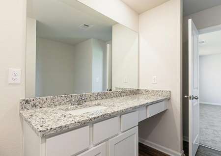 The master bathroom has a spacious vanity and large mirror, making getting ready a breeze
