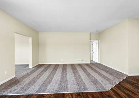 Photo of spacious family room with carpet and adjoining dining room and four-season porch.