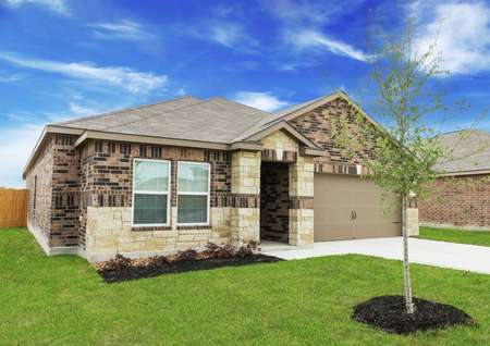 Kendall new home exterior view with landscaped yard, shade tree, and custom finished siding with brick and stone