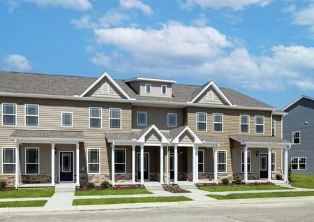Angled view of the front elevation of a 4-unit townhome building at Huntington Pointe featuring from left to right the Hampton, Carol, William and York floor plans.