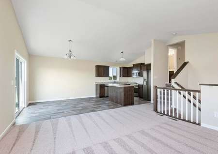 Photo of open entertaining space with a family room, dining room and kitchen with island.