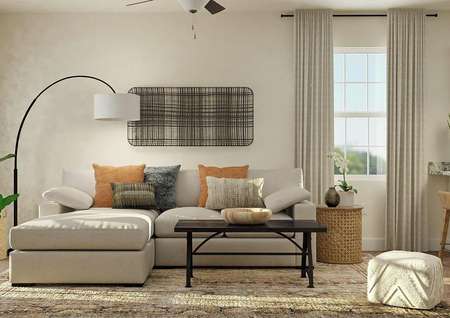 Rendering of the spacious living room in the Maple with tan walls, carpeted flooring and windows. The space is decorated with a spacious couch, standing lamp, coffee table and large rug.