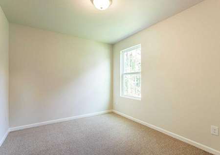 Alexander bedroom with cream walls, white trim, and tan carpet