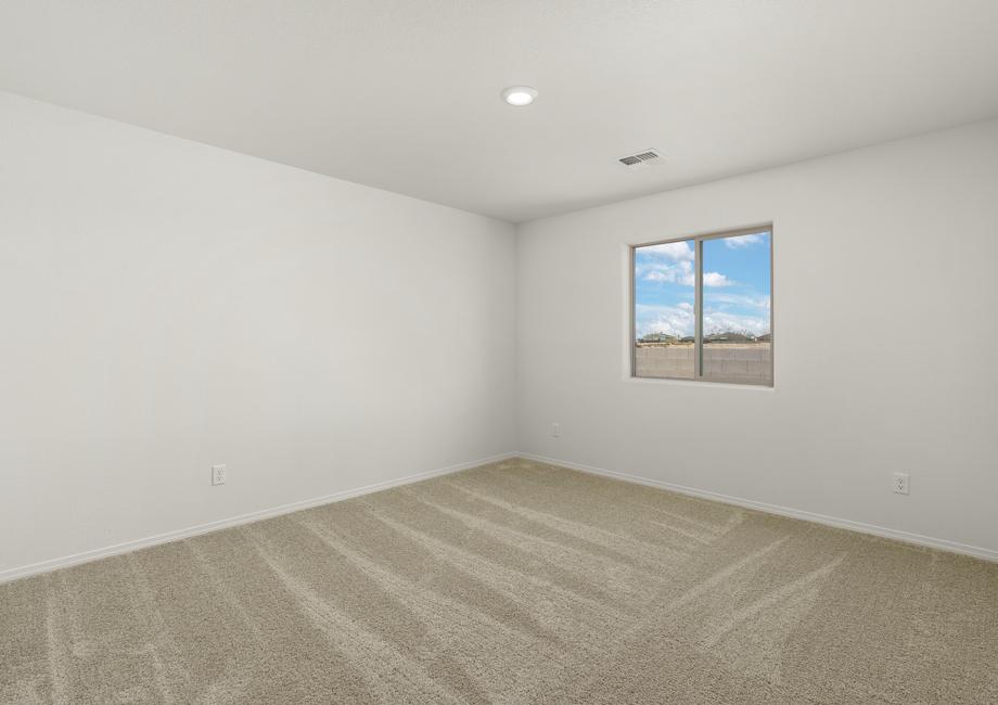 Secondary bedroom with a window and tan carpet. 