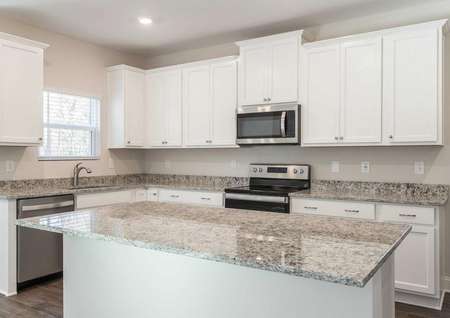 Kitchen with large granite island and stainless steel kitchen appliances. 