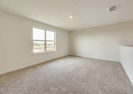 The upstairs game room has brown carpet and light walls.