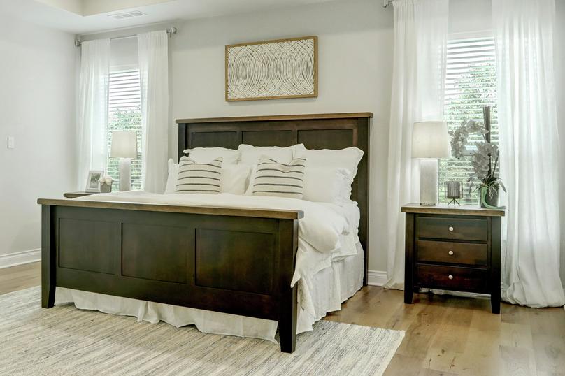 Spacious master suite with tray ceiling and wood floors.