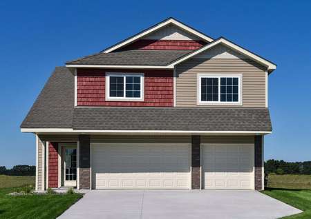 Front exterior of the two-story St Harrison plan by LGI Homes with red and tan siding, a covered front porch, a 3-car garage and lush green grass.