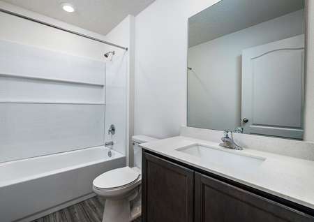 Full bathroom with vinyl plank flooring, recessed lighting and great storage space.