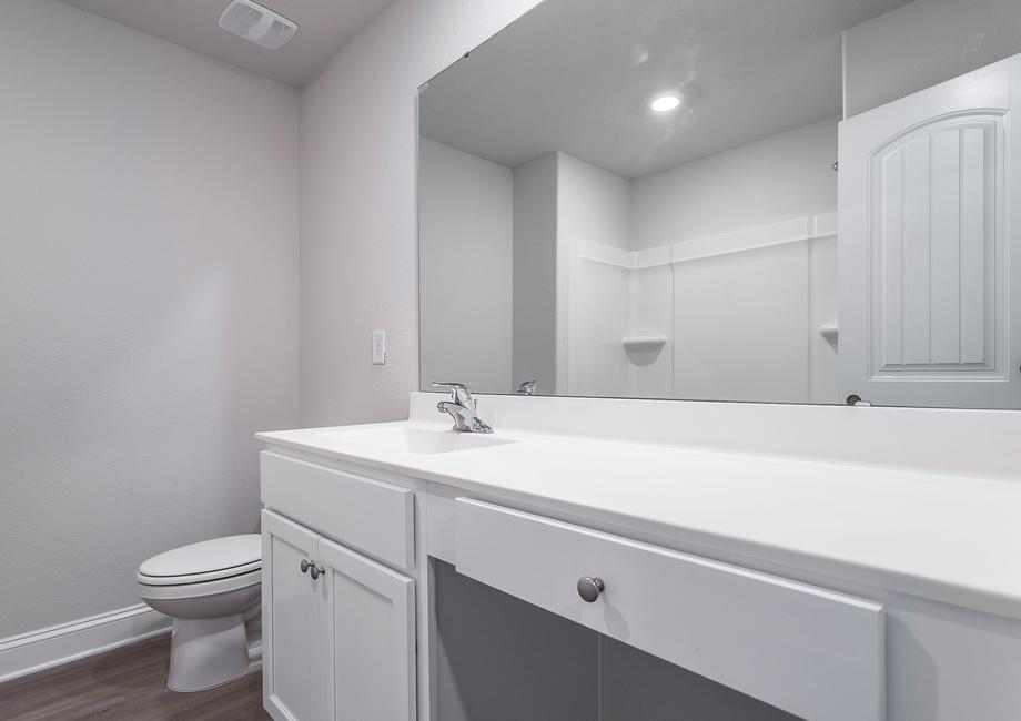 Secondary bathroom with white cabinets.