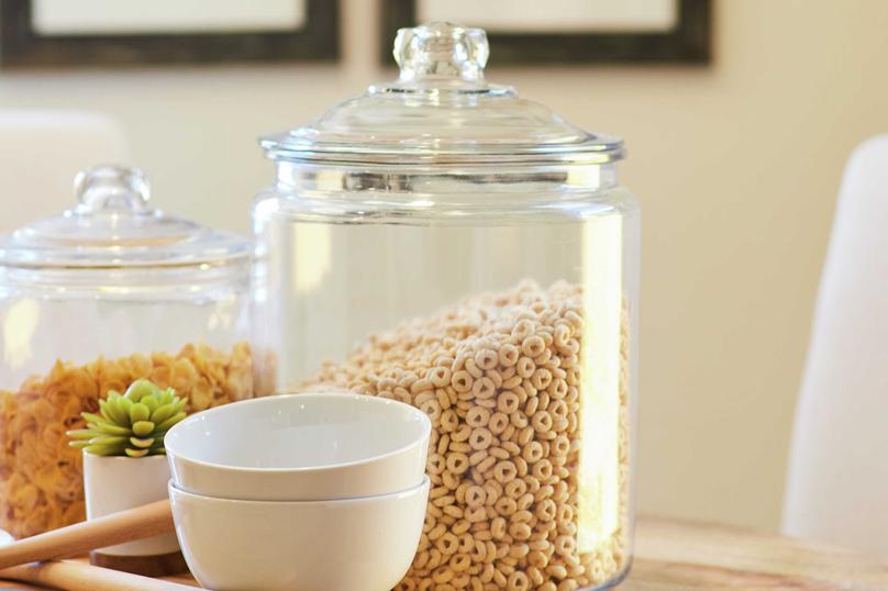 This kitchen is decorated with jars containing cereal, noodles, and white bowls.