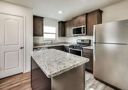 The kitchen has a full suite of stainless steel appliances and brown cabinetry.