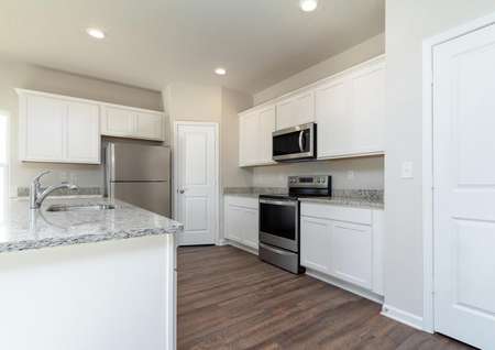 Chef-ready kitchen with white cabinets and stainless steel appliances. 