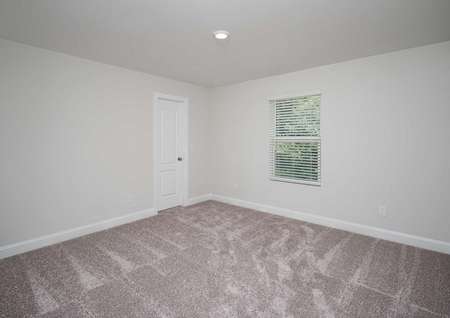 Carpeted secondary room of the Kiawah floor plan with a closet, white walls and a single hung window covered by blinds.