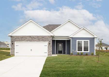 Front elevation photo of the Anna plan by LGI Homes with blue and white siding and gray stone.